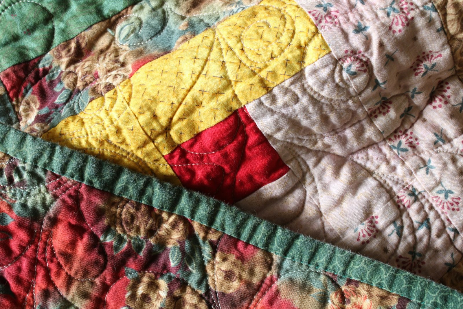 Bed dressed with a colourful quilt
