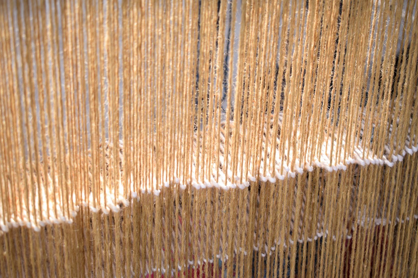 Golden threads hanging on a loom